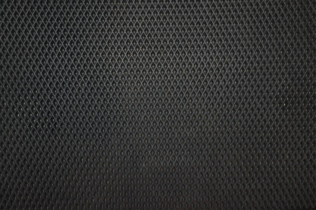 Black rubber car mat as background, top view