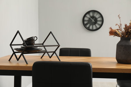 Wooden table with black chairs in stylish dining room