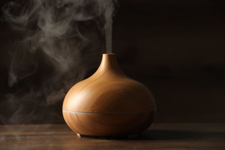 Aroma oil diffuser with steam on wooden tableの写真素材