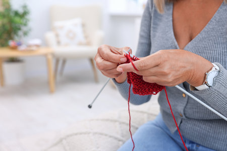 Woman knitting at home, closeup. Space for text
