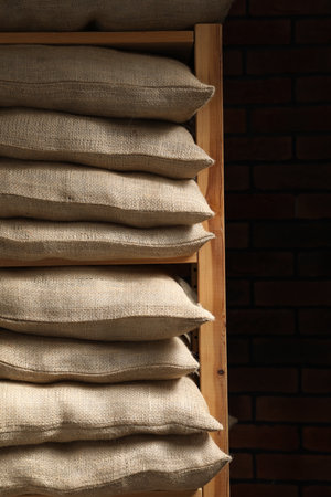 Group of burlap sacks on shelving unit near brick wallの写真素材