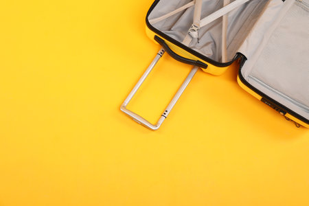 Open empty suitcase on yellow background, top view. Space for textの写真素材