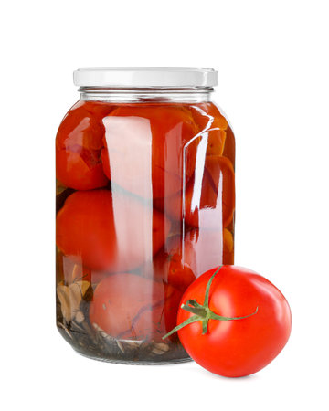 Tasty pickled tomatoes in jar and fresh vegetable isolated on whiteの写真素材