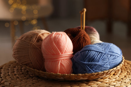 Knitting material. Skeins of soft yarn in wicker bowl on table, closeupの写真素材