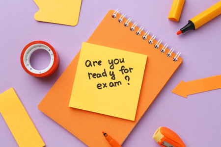 Paper note with question Are You Ready For Exam and stationery on purple background, flat layの写真素材