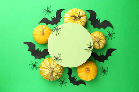 Halloween celebration. Black paper bats, spiders, pumpkins and podium on green background, flat layの写真素材