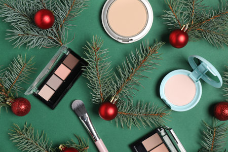 Flat lay composition with makeup products and Christmas decor on green backgroundの写真素材