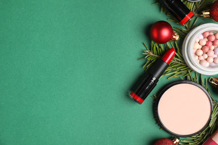 Flat lay composition with makeup products and Christmas decor on green background, space for textの写真素材