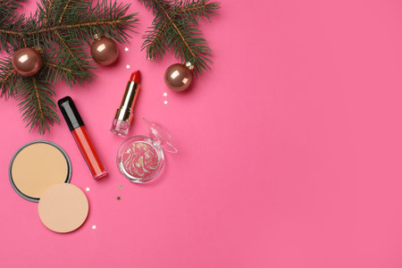 Flat lay composition with makeup products and Christmas decor on pink background. Space for textの写真素材