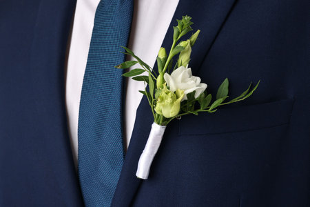 Groom in suit with stylish boutonniere, closeup