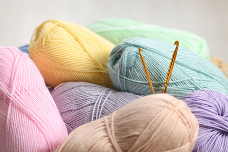 Knitting material. Skeins of soft yarn and crochet hooks indoors, closeup