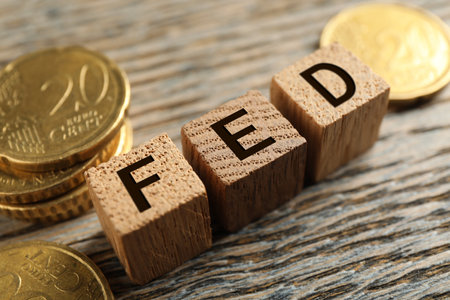 Cubes with letters Fed (Federal Reserve System) and coins on wooden table, closeupの写真素材