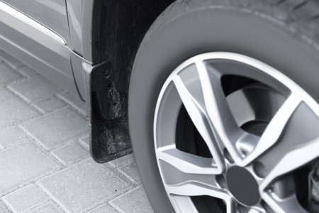 Modern gray car parked on paved road, closeup