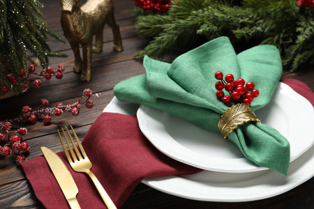 Christmas place setting with festive decor on wooden table, closeup