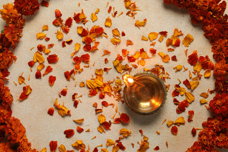 Diwali celebration. Diya lamp and beautiful flowers on light background, top view