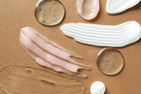 Smears of different cosmetic products on brown background, flat layの写真素材