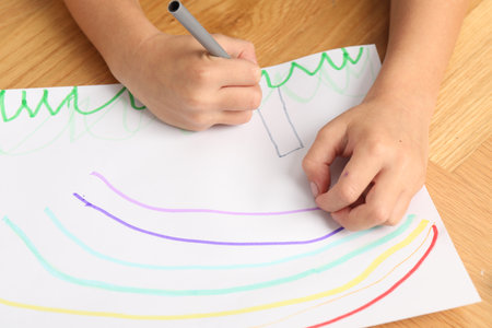 Boy drawing picture at wooden table, closeupの写真素材