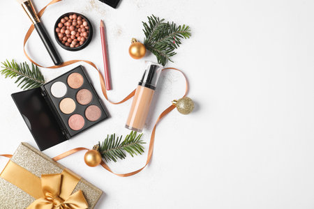 Flat lay composition with makeup products and Christmas decor on white background, space for textの写真素材