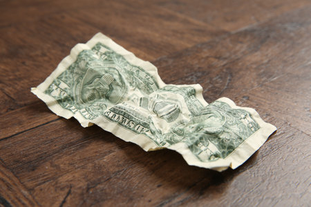 One crumpled dollar banknote on wooden table, closeupの写真素材