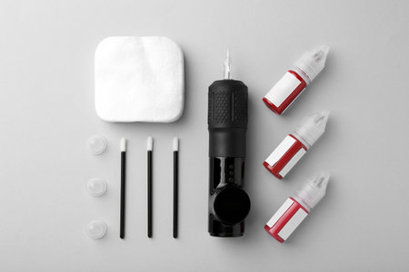 Permanent makeup equipment kit on light gray background, flat layの写真素材
