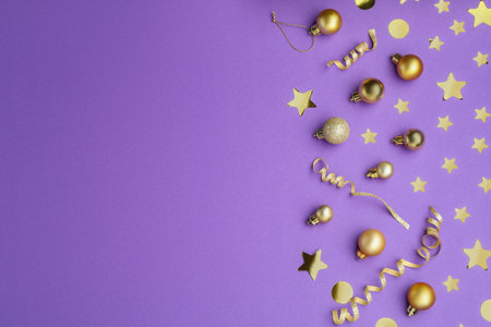 Beautiful Christmas baubles and confetti on purple background, flat lay. Space for textの写真素材