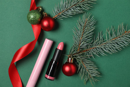 Flat lay composition with makeup products and Christmas decor on green backgroundの写真素材