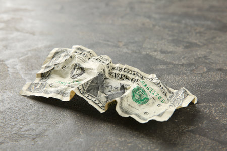 One crumpled dollar banknote on gray table, closeupの写真素材