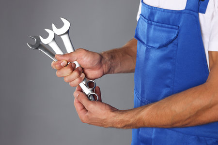 Auto mechanic with wrenches on gray background, closeupの写真素材