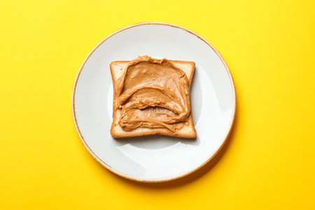 Delicious sandwich with peanut butter on yellow table, top viewの写真素材