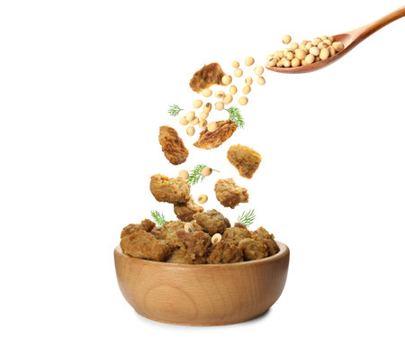 Soy meat and beans falling into bowl on white backgroundの写真素材