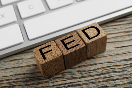 Cubes with letters Fed (Federal Reserve System) and keyboard on wooden table
