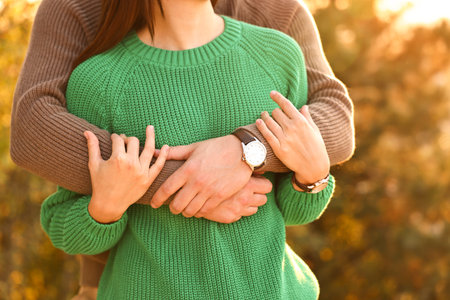Couple hugging outdoors in autumn evening, closeup viewの写真素材