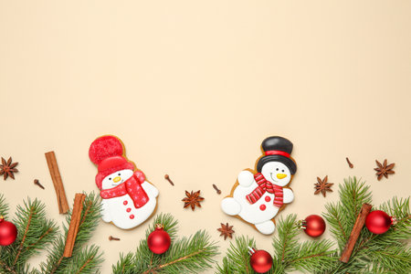 Flat lay composition with Christmas decor and delicious cookies in shape of snowmen on beige background, space for textの写真素材