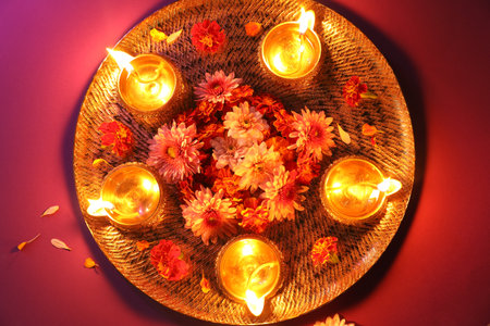 Diwali celebration. Diya lamps and beautiful flowers on color background, top viewの写真素材