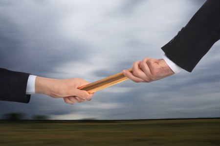 Businessman passing relay baton to colleague outdoors, closeupの写真素材
