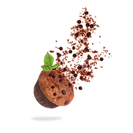 Yummy muffin and chocolate chips in air on white backgroundの写真素材