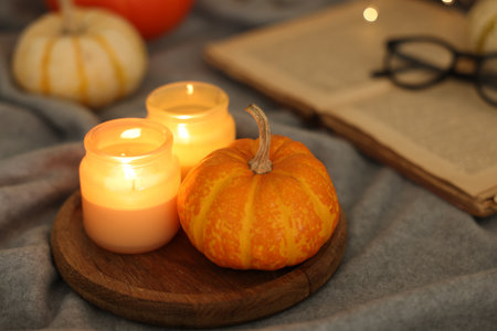 Burning candles and pumpkin on gray cloth, closeup. Autumn atmosphereの写真素材
