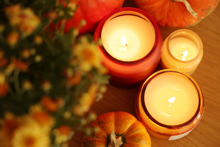 Burning candles, flowers and pumpkins on table, above view. Autumn atmosphereの写真素材