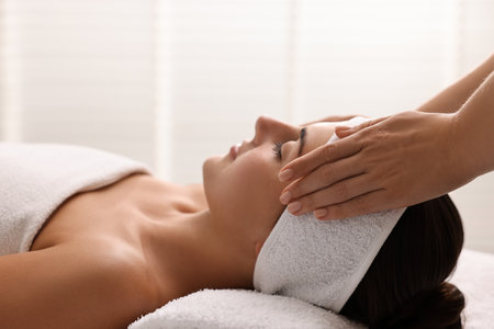 Attractive woman enjoying face massage, closeup. Beauty procedureの写真素材