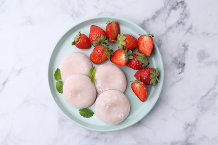 Delicious mochi, strawberries and mint on white marble table, top viewの写真素材