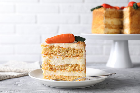 Plate with piece of delicious carrot cake on gray textured table, closeup