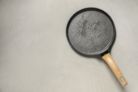 Frying pan with oil on gray textured table, top view. Space for textの写真素材