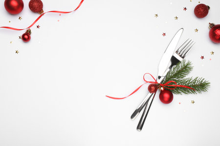 Christmas table setting. Cutlery and festive decor on white background, flat lay. Space for text