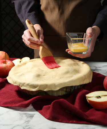 Woman making homemade apple pie at white marble table, closeupの写真素材