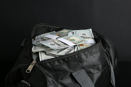 Dollar banknotes in bag on black background, closeupの写真素材