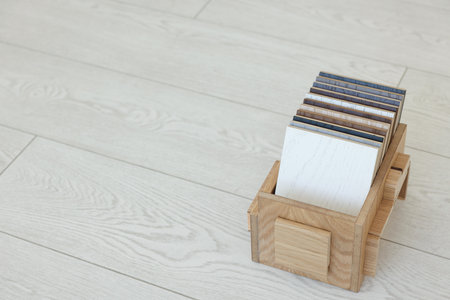 Different samples of wooden flooring in crate indoors, space for textの写真素材