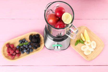 Blender and fresh ingredients on pink wooden table, above viewの写真素材