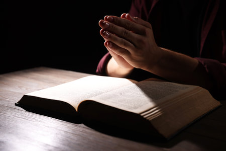 Man with Bible praying at wooden table, closeupの写真素材