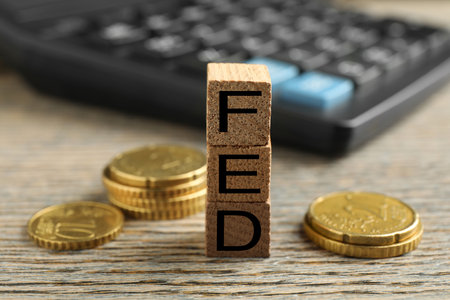 Cubes with letters Fed (Federal Reserve System) and coins on wooden table, closeupの写真素材