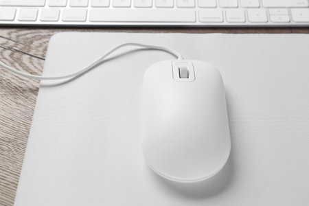 Computer mouse with mousepad and keyboard on wooden table